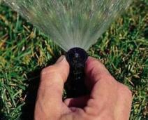 Our Commerce City Sprinkler Installation Team adjusts sprinkler heads
